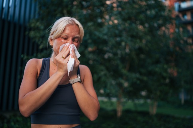Young sporty woman blowing her nose after training outdoors