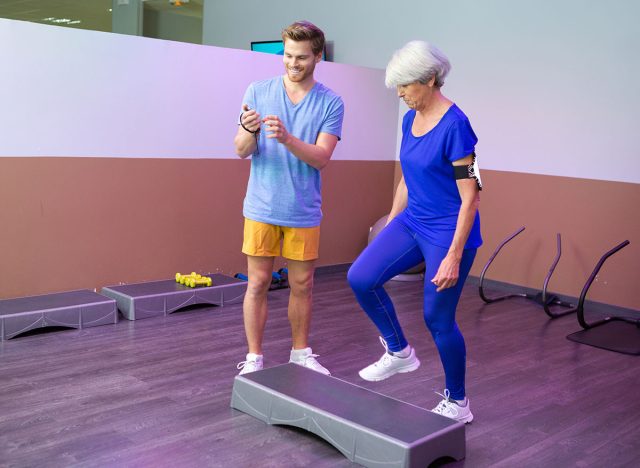 Athletic female senior doing aerobic exercise class