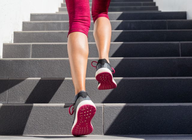 Close-up female legs, hot pink sneakers going up steps, exercising