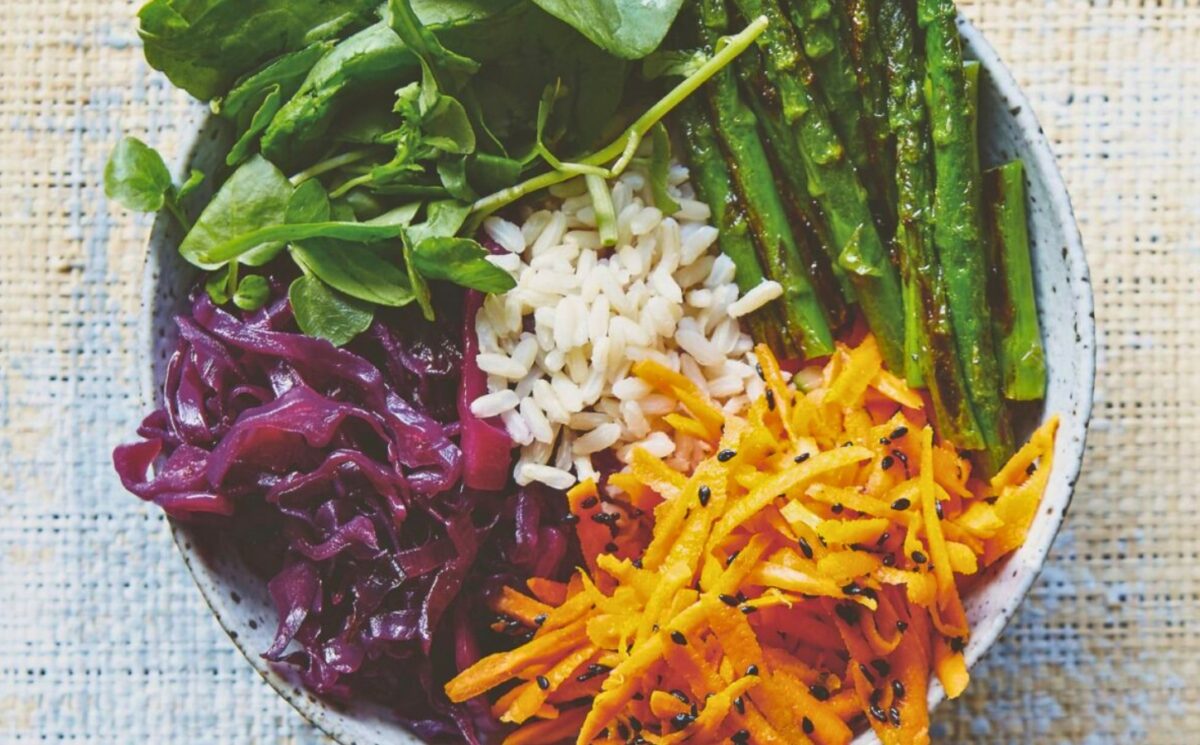 Vegan bibimbap with cabbage, white rice, shallots, sweet and sour dressing, and asparagus for a gluten-free lunch idea