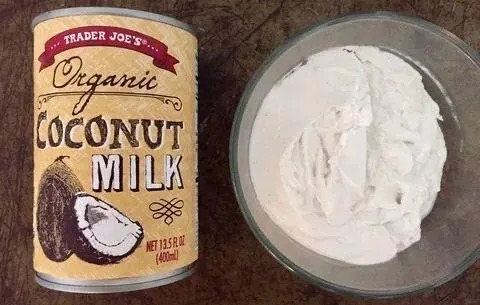 A can of Trader Joe's organic coconut milk next to a bowl of coconut milk