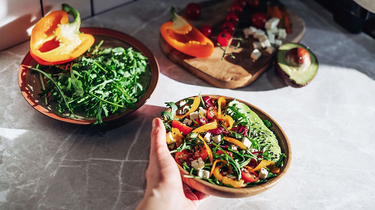 Woman's hand holding a salad bowl with vegetables