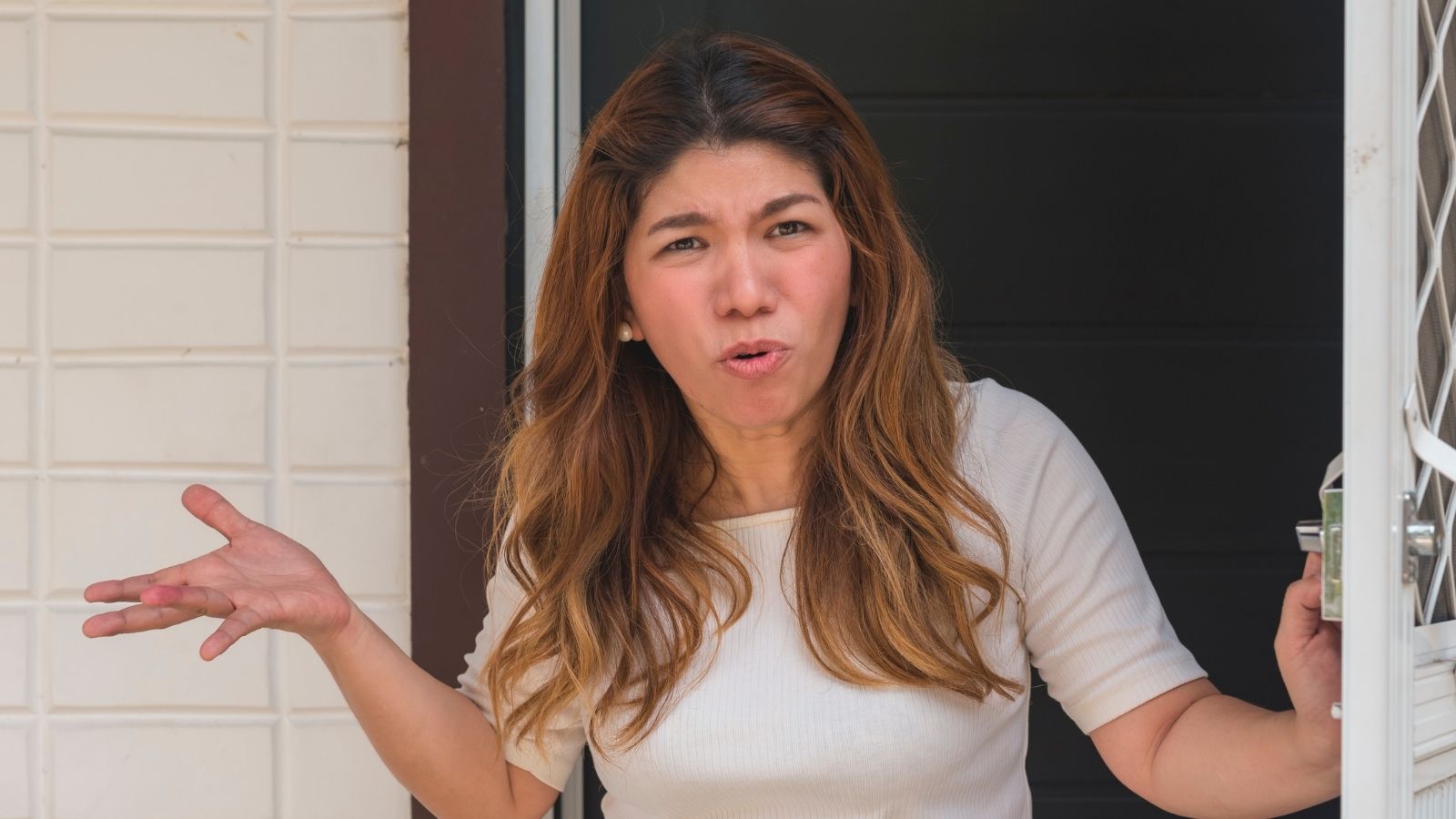 An upset woman opens the front door